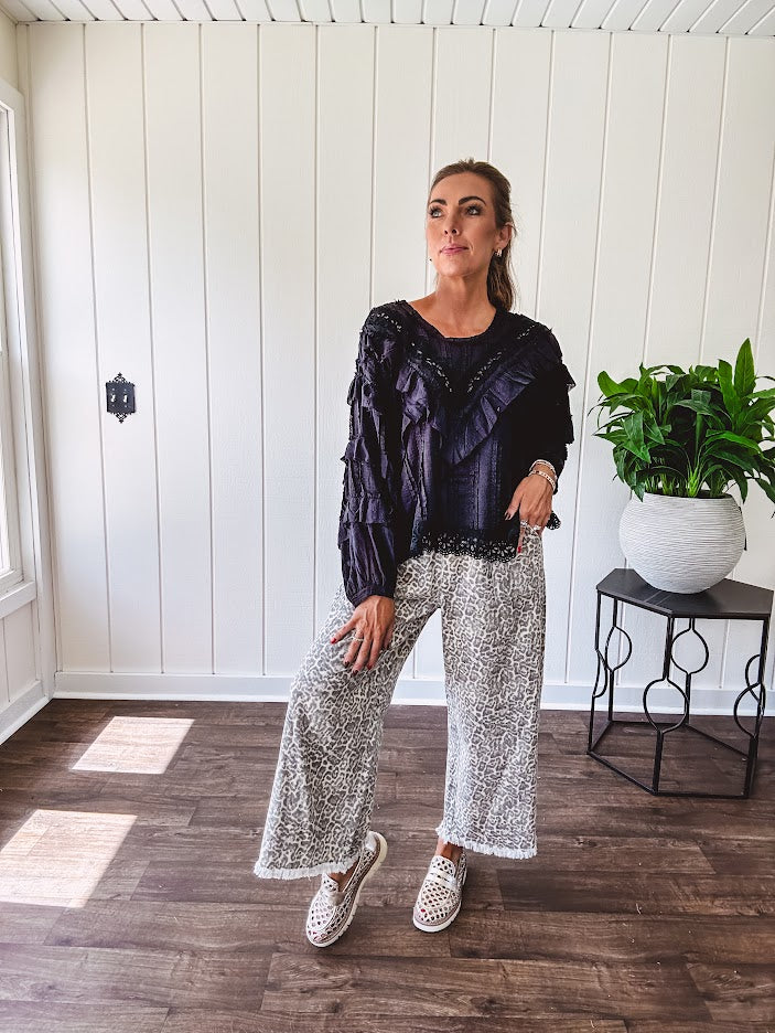 Light wash leopard print elastic waist wide leg pants with frayed hem.