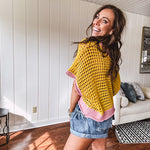 Open weave crochet sweater with 3/4 sleeves and large contrasting crochet flower on the front and contrasting trim. Oversized. Available in multiple colors.