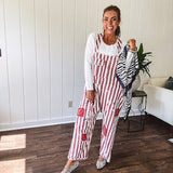 Cream and crimson striped overalls with button adjustable straps and sides with paint splatter and patchwork detail throughout.