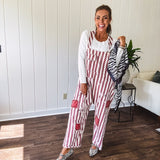 Cream and crimson striped overalls with button adjustable straps and sides with paint splatter and patchwork detail throughout.