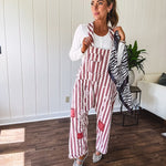 Cream and crimson striped overalls with button adjustable straps and sides with paint splatter and patchwork detail throughout.