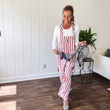 Cream and crimson striped overalls with button adjustable straps and sides with paint splatter and patchwork detail throughout.