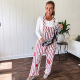 Cream and crimson striped overalls with button adjustable straps and sides with paint splatter and patchwork detail throughout.
