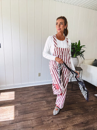 Cream and crimson striped overalls with button adjustable straps and sides with paint splatter and patchwork detail throughout.