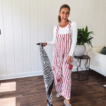 Cream and crimson striped overalls with button adjustable straps and sides with paint splatter and patchwork detail throughout.