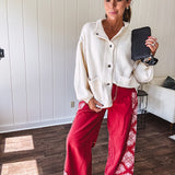 Soft cream snap front cardigan with front pockets and balloon style sleeves with ribbed collar.