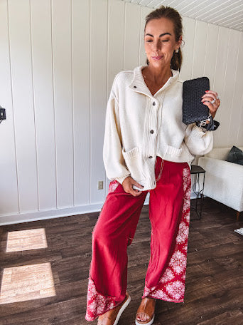Soft cream snap front cardigan with front pockets and balloon style sleeves with ribbed collar.