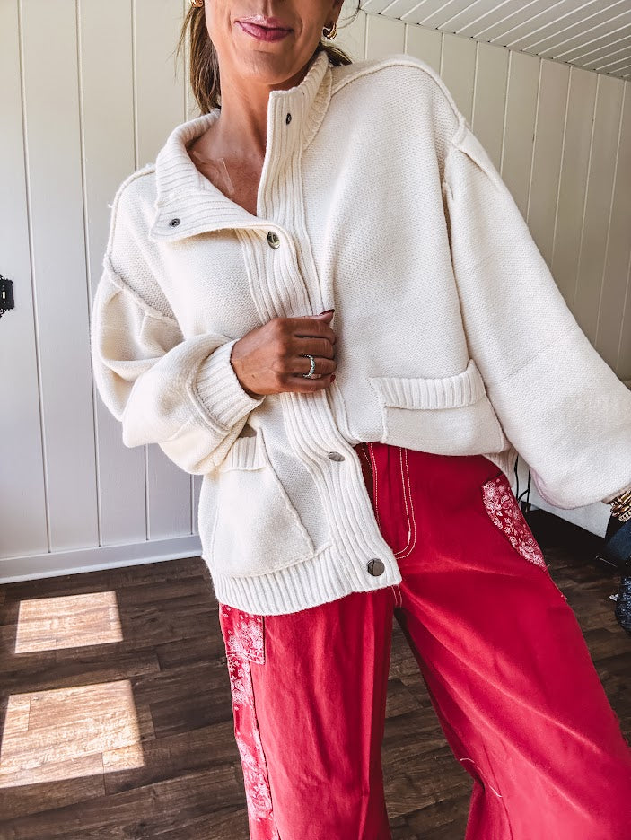Soft, cozy cream snap button front cardigan with collar, exposed seam detail, balloon sleeves and front pockets.