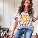 Open weave crochet sweater with 3/4 sleeves and large contrasting crochet flower on the front and contrasting trim. Oversized. Available in multiple colors.