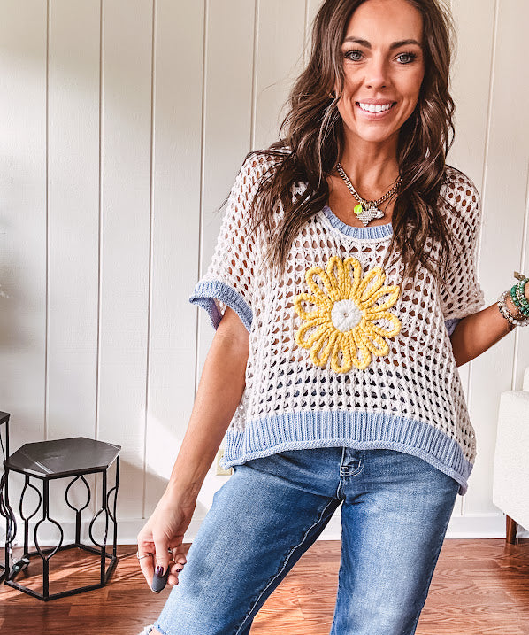 Open weave crochet sweater with 3/4 sleeves and large contrasting crochet flower on the front and contrasting trim. Oversized. Available in multiple colors.
