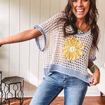 Open weave crochet sweater with 3/4 sleeves and large contrasting crochet flower on the front and contrasting trim. Oversized. Available in multiple colors.
