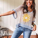 Open weave crochet sweater with 3/4 sleeves and large contrasting crochet flower on the front and contrasting trim. Oversized. Available in multiple colors.