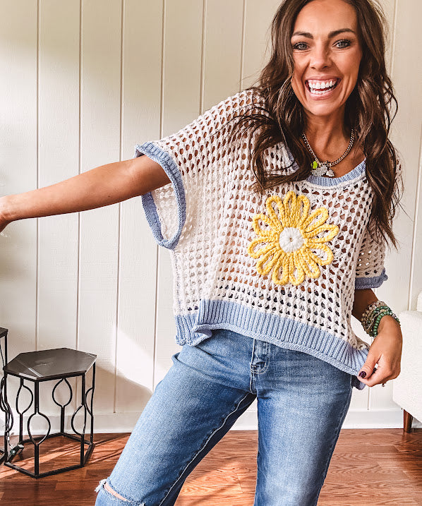 Open weave crochet sweater with 3/4 sleeves and large contrasting crochet flower on the front and contrasting trim. Oversized. Available in multiple colors.