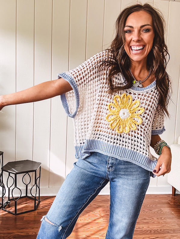 Open weave crochet sweater with 3/4 sleeves and large contrasting crochet flower on the front and contrasting trim. Oversized. Available in multiple colors.