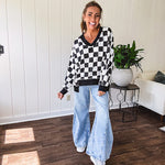 Lightweight black and white checkered long sleeve pullover with contrasting black V neck and cutout hem, with pockets.
