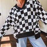 Lightweight black and white checkered long sleeve pullover with contrasting black V neck and cutout hem, with pockets.