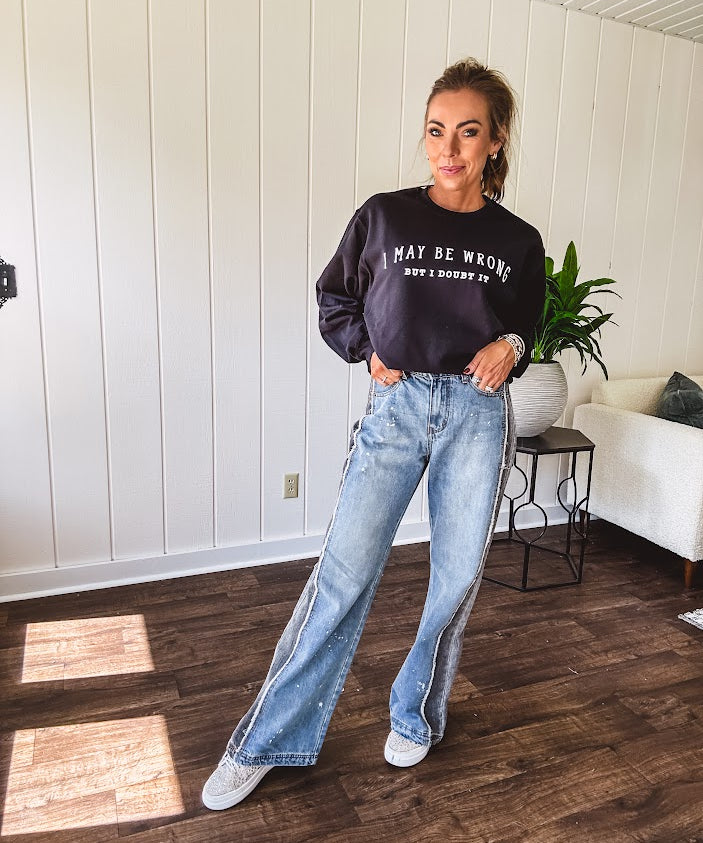 Wide leg medium washed denim pants featuring a washed black colorblock design on the outer legs and back pockets with exposed seams, bleach details and finished seams.