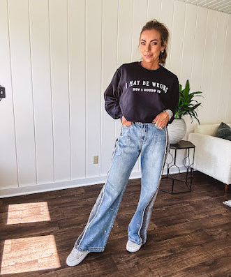 Wide leg medium washed denim pants featuring a washed black colorblock design on the outer legs and back pockets with exposed seams, bleach details and finished seams.