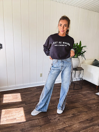 Wide leg medium washed denim pants featuring a washed black colorblock design on the outer legs and back pockets with exposed seams, bleach details and finished seams.