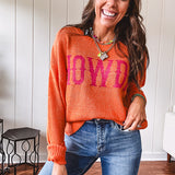 Lightweight, nearly sheer orange long sleeved sweater with hot pink "HOWDY" in western style graphic on front.
