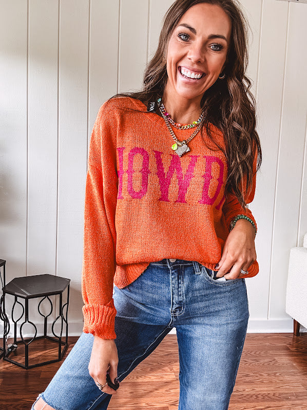 Lightweight, nearly sheer orange long sleeved sweater with hot pink "HOWDY" in western style graphic on front.