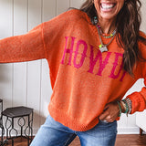 Lightweight, nearly sheer orange long sleeved sweater with hot pink "HOWDY" in western style graphic on front.