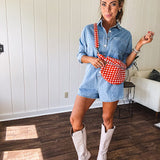 Lightweight light wash denim shorts romper with long sleeves, silver buttons down the front and classic collar with front pocket.