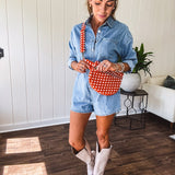 Lightweight light wash denim shorts romper with long sleeves, silver buttons down the front and classic collar with front pocket.
