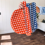 Quilted belt bag featuring zippered pockets and a gingham pattern available in several colors.