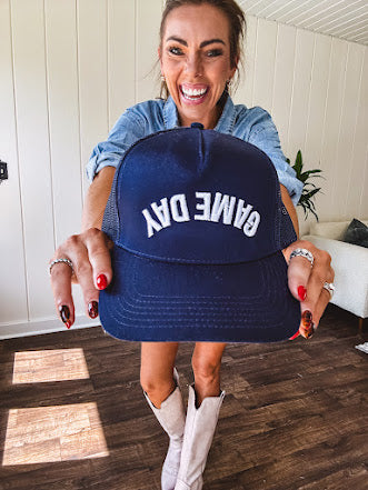 White canvas hat with black bill and black puff embroidered, backwards "Game Day" lettering on front.