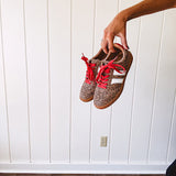 Mini leopard print sneakers with white stripes on the sides and contrasting red laces.