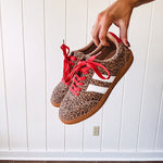 Mini leopard print sneakers with white stripes on the sides and contrasting red laces.