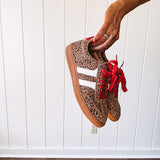 Mini leopard print sneakers with white stripes on the sides and contrasting red laces.