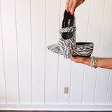 Cream and black zebra print ballet flat with pointed tow, Mary Jane style buckle across the top and silver rivet holes throughout.