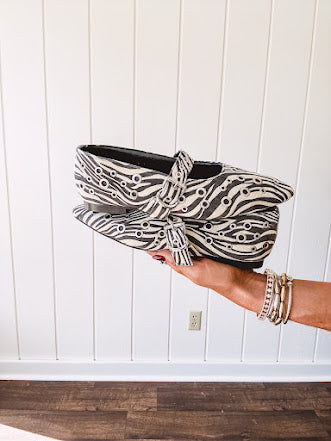 Cream and black zebra print ballet flat with pointed tow, Mary Jane style buckle across the top and silver rivet holes throughout.