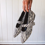 Cream and black zebra print ballet flat with pointed tow, Mary Jane style buckle across the top and silver rivet holes throughout.