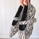 Cream and black zebra print ballet flat with pointed tow, Mary Jane style buckle across the top and silver rivet holes throughout.