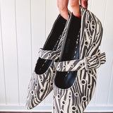 Cream and black zebra print ballet flat with pointed tow, Mary Jane style buckle across the top and silver rivet holes throughout.