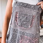 Washed black and pink patchwork jumpsuit with leo and floral print throughout, wide leg design, raw hems, adjustable straps and sides.