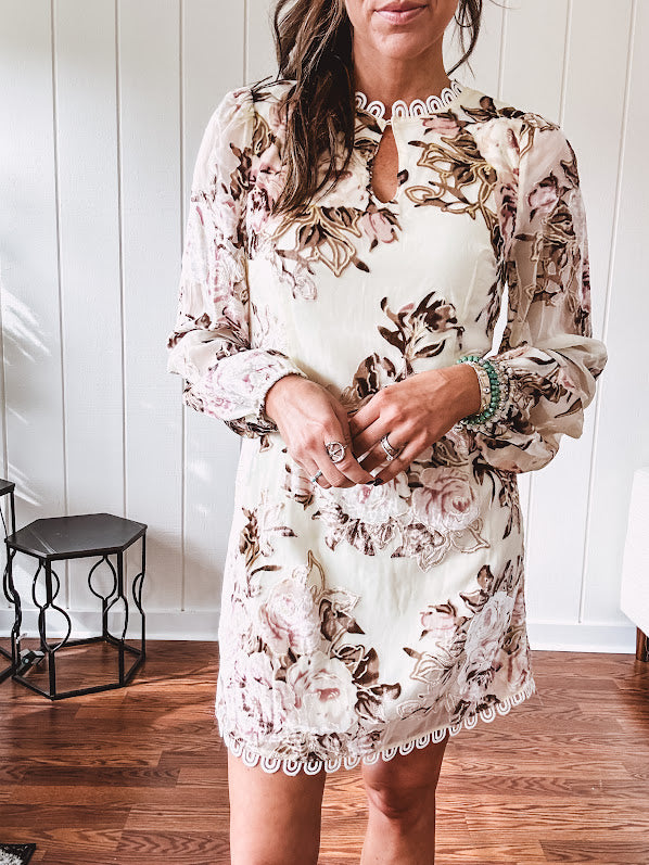 Mini dress in ivory with vintage floral design, fully lined, sheet long sleeves, lace detail at the eyelet neckline and collar and hem. Zip up back.