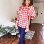Red and tan windowpane check blouse withp uff sleeve, round neck and flowy hem.