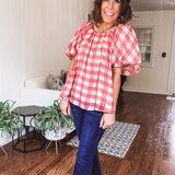 Red and tan windowpane check blouse withp uff sleeve, round neck and flowy hem.