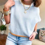 Ice blue washed sweater tank with white trim at sleeves and collar and orange trim at the hem.