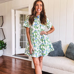 Cream shirt dress with blue and green floral print throughout, contrasting blue trim at the covered placket and hem, cuffed sleeves, mini length, fully lined.