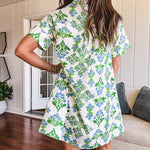 Cream shirt dress with blue and green floral print throughout, contrasting blue trim at the covered placket and hem, cuffed sleeves, mini length, fully lined.
