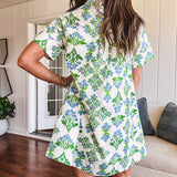 Cream shirt dress with blue and green floral print throughout, contrasting blue trim at the covered placket and hem, cuffed sleeves, mini length, fully lined.