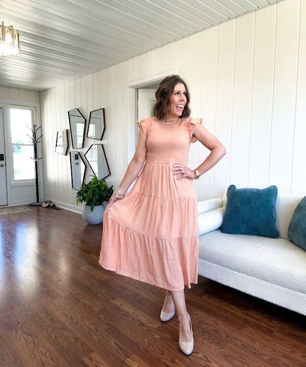 Apricot midi dress with smocked bodice, ruffle sleeves and tiered lined skirt.