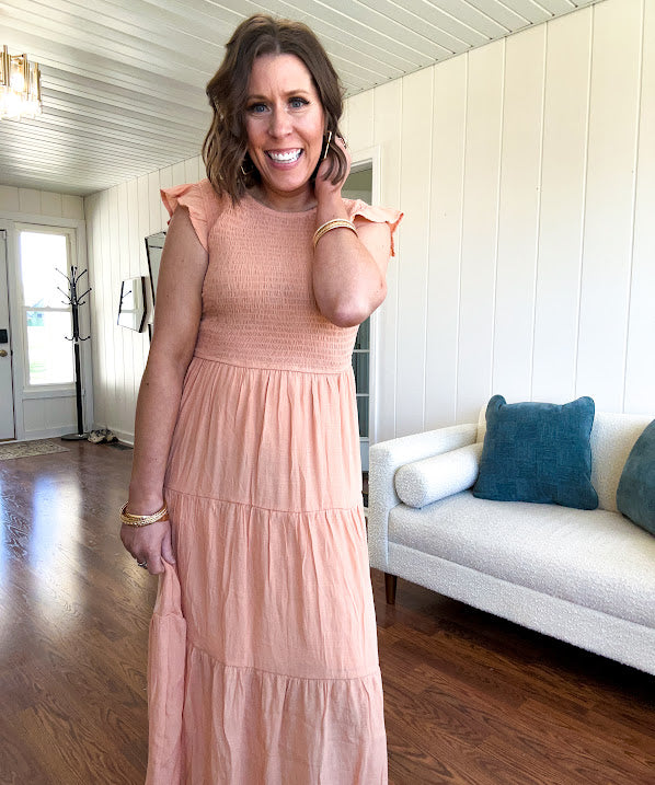 Apricot midi dress with smocked bodice, ruffle sleeves and tiered lined skirt.