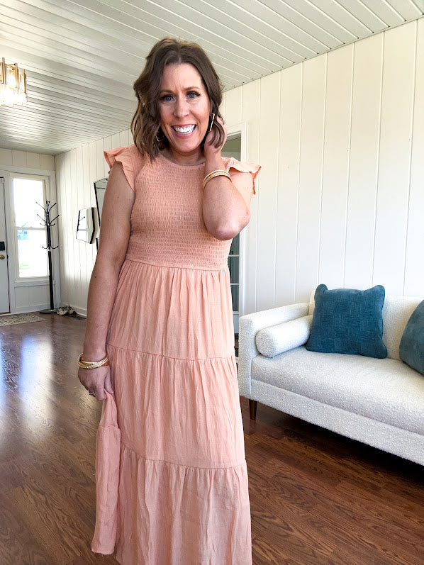 Apricot midi dress with smocked bodice, ruffle sleeves and tiered lined skirt.