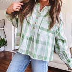 Light apple green and white plaid and gingham print long sleeved top with 1/4 wooden button down front and pleat at placket.